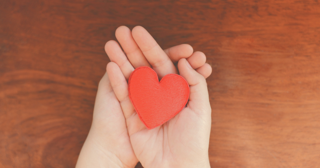 認知症の家族への対応で気を付けたいことの見出しの画像 両手に小さなハートを持っている